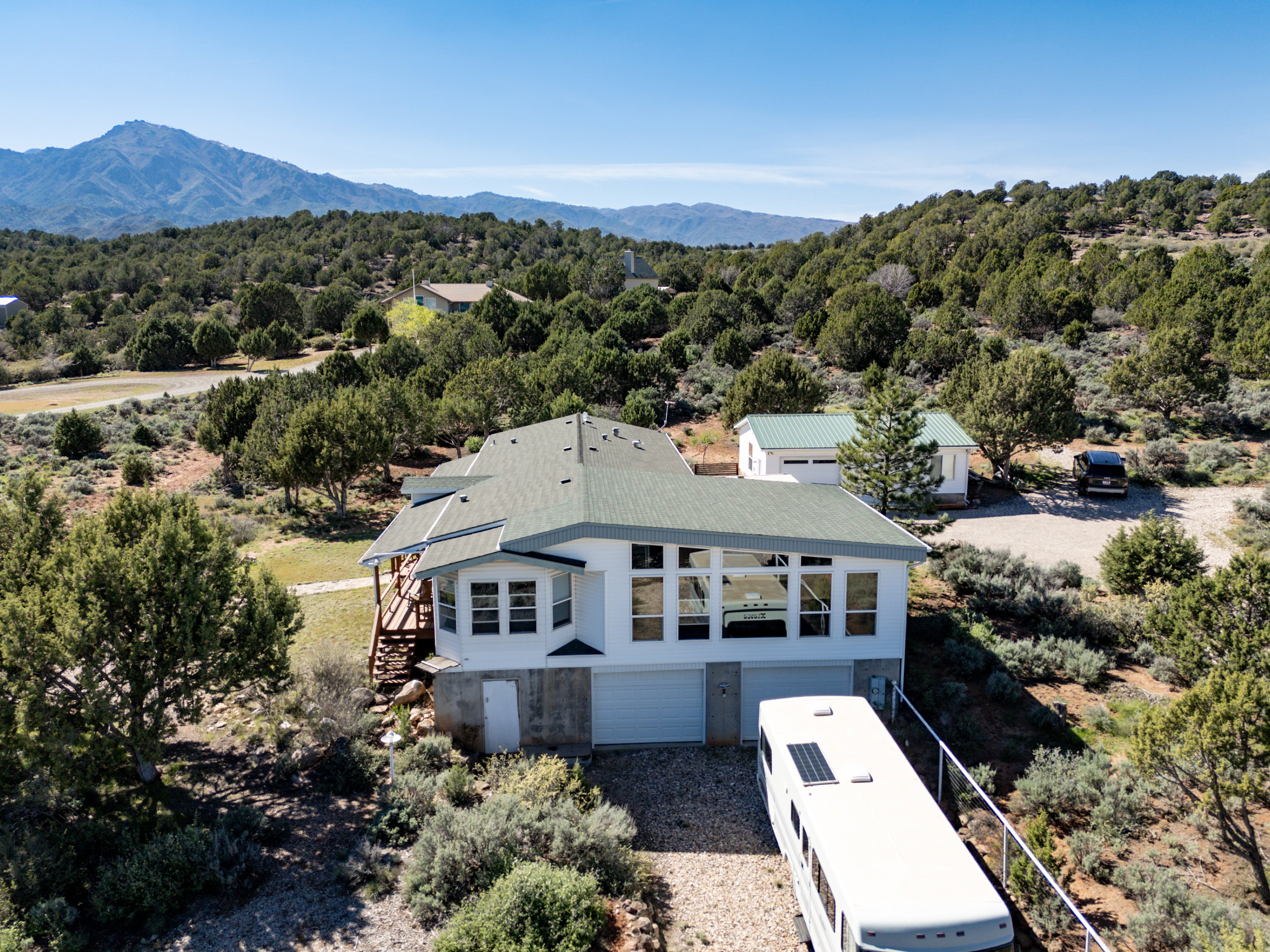 View from above of property featuring a mountain backdrop and a forest