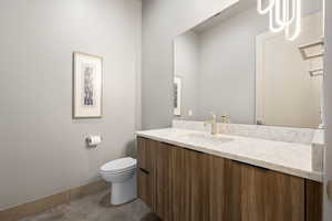 Half bath featuring vanity and concrete flooring