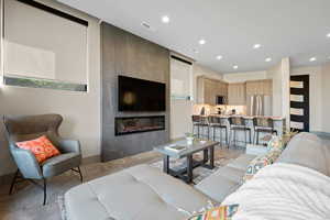 Living area featuring recessed lighting, a fireplace, and concrete floors