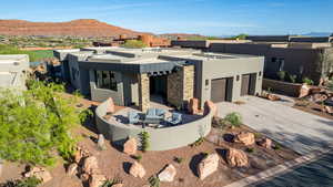 Rear view of property featuring stucco siding, a mountain view, outdoor furniture, concrete driveway, and a garage