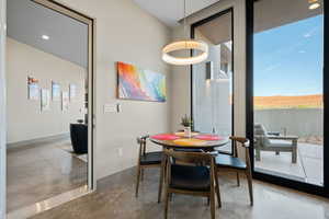 Dining space featuring finished concrete flooring, expansive windows, and healthy amount of natural light