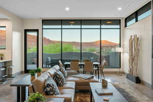 Living room featuring finished concrete floors, a mountain view, floor to ceiling windows, and recessed lighting