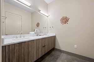 Full bath featuring double vanity and dark tile patterned flooring