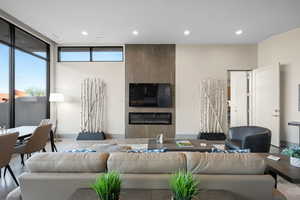 Living room with a tiled fireplace, recessed lighting, and expansive windows