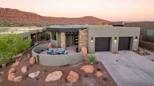 View of front of house with a garage, driveway, stucco siding, a mountain view, and an outdoor living space