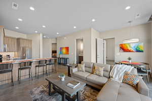 Living area with finished concrete flooring and recessed lighting