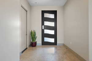 Entryway featuring finished concrete floors and baseboards