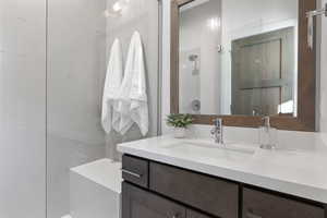 Full bath with vanity and a tile shower