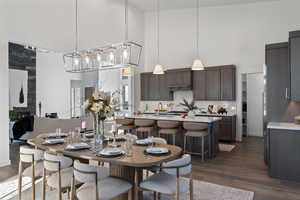 Dining area featuring a high ceiling and dark wood-style floors