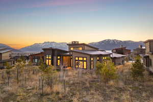 Back of property featuring a mountain view, a patio, and a metal roof