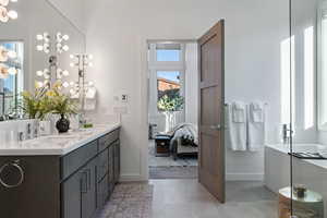 Ensuite bathroom featuring double vanity and a soaking tub