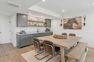 Dining room featuring light wood finished floors, recessed lighting, and wet bar