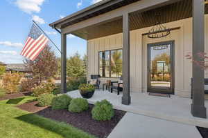 View of exterior entry with covered porch and board and batten siding