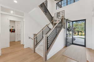 Stairs with wood finished floors and baseboards