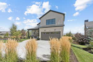 Modern farmhouse style home with an attached garage, board and batten siding, and concrete driveway