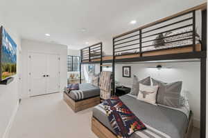 Bedroom with light colored carpet, recessed lighting, and a closet