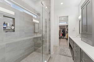 Full bath with vanity, a spacious closet, a stall shower, and recessed lighting