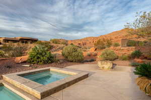 View of pool with patio surround, an in-ground hot tub, and a mountain view