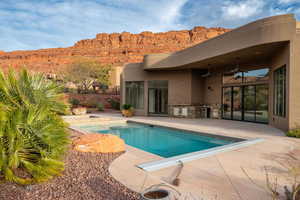 View of swimming pool featuring exterior kitchen and patio surround