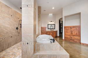 Full bath with walk in shower, a tub with jets, recessed lighting, vanity, and concrete floors
