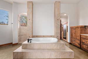 Bathroom with a garden tub, a walk in shower, and vanity