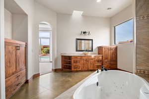 Bathroom with vanity and a tub with jets