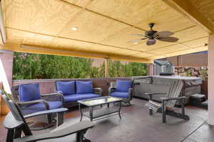 Fenced backyard featuring ceiling fan, a hot tub, outdoor lounge area, and a patio area