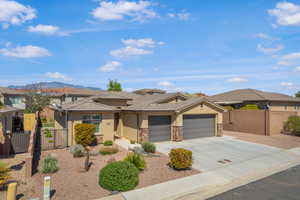 Prairie-style house with stucco siding, concrete driveway, an attached garage, a residential view, and stone siding