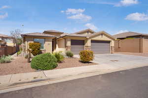 View of front facade with concrete driveway, stucco siding, stone siding, an attached garage, and a tile roof