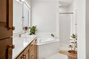 Bathroom featuring vanity, a stall shower, a bath, and light tile patterned floors