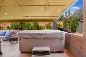 View of patio / terrace with a hot tub and an outdoor hangout area