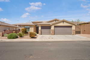 View of front of house featuring a gate, stone siding, stucco siding, and concrete driveway