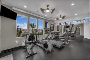 Gym with a ceiling fan and recessed lighting