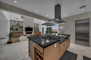 Kitchen with island exhaust hood, beverage cooler, stainless steel appliances, modern cabinets, and a center island