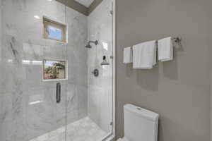 Full bathroom featuring toilet and a stall shower