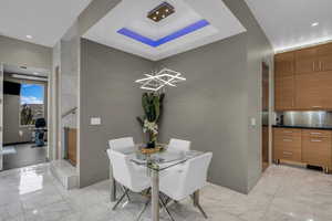 Dining room with recessed lighting and a tray ceiling