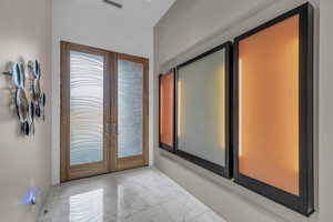 Doorway featuring french doors and marble look tiles