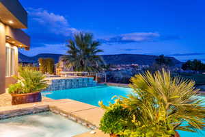 Outdoor pool with a mountain view, an in-ground hot tub, and a patio area
