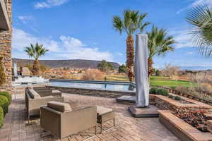 View of patio / terrace with an outdoor pool and a mountain view