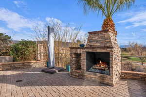View of patio / terrace featuring an outdoor stone fireplace