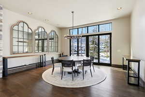 Dining area with dark wood-style flooring, a chandelier, and recessed lighting