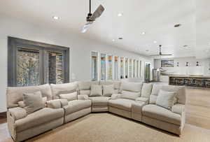 Living room with a ceiling fan, recessed lighting, and wood finished floors