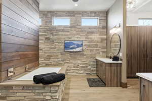 Bathroom with vanity, a bath, light wood finished floors, and recessed lighting