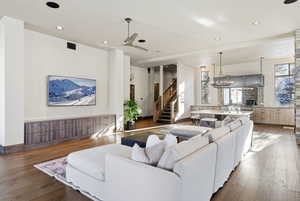 Living area with ceiling fan, hardwood / wood-style flooring, recessed lighting, stairway, and a chandelier