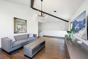 Living room with dark wood finished floors, a chandelier, and recessed lighting