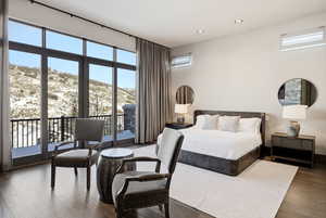 Bedroom featuring a mountain view, wood finished floors, multiple windows, access to outside, and recessed lighting