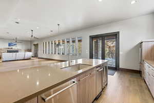Kitchen with recessed lighting, light wood-style floors, dishwasher, pendant lighting, and open floor plan