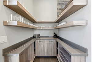 Bar area featuring dark wood finished floors and light brown cabinetry