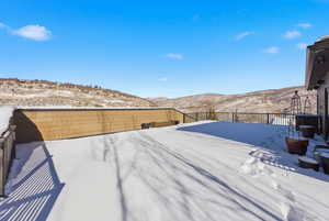 Yard covered in snow featuring a mountain view