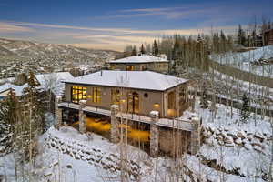 Snow covered back of property with a mountain view